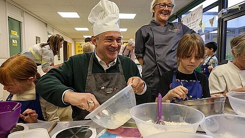 Picture of Ed Davey cooking in a school